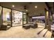 Inviting covered patio with stone accents, comfortable seating, and seamless indoor-outdoor flow through sliding glass doors at 9127 N Fireridge Trl, Fountain Hills, AZ 85268