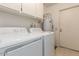 Functional laundry room with a washer, dryer, water heater, and overhead cabinets for storage at 15462 N Lakeforest Dr, Sun City, AZ 85351