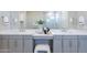Bathroom with dual sinks, vanity, and soft gray cabinetry at 17894 W Hood River Rd, Surprise, AZ 85388