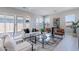 Spacious living room with contemporary furniture, a glass coffee table, and large windows at 17894 W Hood River Rd, Surprise, AZ 85388