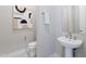 Modern powder room features a pedestal sink, geometric art, and neutral tones at 17894 W Hood River Rd, Surprise, AZ 85388
