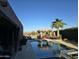 Luxury home's inviting pool area features a palapa bar and desert landscaping at 1932 E Beck Ln, Phoenix, AZ 85022