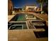 An inviting swimming pool with a covered outdoor structure surrounded by palm trees and warm lighting at 1932 E Beck Ln, Phoenix, AZ 85022