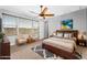 Relaxing primary bedroom featuring a ceiling fan, hardwood floors, two comfy chairs and plenty of natural light at 22131 E Estrella Rd, Queen Creek, AZ 85142
