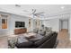 Spacious living room with hardwood floors, multiple seating areas, a large ceiling fan, and plenty of natural light at 22131 E Estrella Rd, Queen Creek, AZ 85142