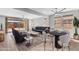 Open-concept living room with access to the backyard, featuring a modern sofa, dining area, and contemporary decor at 22131 E Estrella Rd, Queen Creek, AZ 85142
