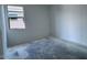 Bright bedroom featuring light-colored walls, concrete floors, and a window overlooking the exterior of the home at 32155 N Lone Rancher Way, San Tan Valley, AZ 85140