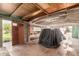 View of a spacious garage with wooden beams and mixed wall materials, with a covered car at 4333 N 15Th Dr, Phoenix, AZ 85015