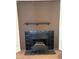 Classic black tiled fireplace with a dark mantel, set against a warm brown wall at 4820 N 89Th Ave # 45, Phoenix, AZ 85037