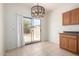 Bright dining area with tile flooring, modern chandelier, and sliding glass door to the backyard at 1384 E Press Rd, San Tan Valley, AZ 85140