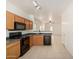 Efficient kitchen with dark countertops, oak cabinets and black appliances, seamlessly connected to the living room at 1384 E Press Rd, San Tan Valley, AZ 85140