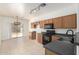 Well-equipped kitchen featuring dark countertops, oak cabinets, and tile flooring with backyard dining view at 1384 E Press Rd, San Tan Valley, AZ 85140