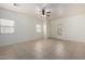 Bright living room with neutral tile flooring, ceiling fan and abundant natural light from large windows at 1384 E Press Rd, San Tan Valley, AZ 85140