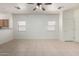 Open-concept living room featuring neutral tile flooring, ceiling fan, with views into the kitchen at 1384 E Press Rd, San Tan Valley, AZ 85140