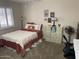 Bedroom featuring a bed with a red comforter and a geometric white blanket, a desk, and a storage cube at 17431 N Boswell Blvd, Sun City, AZ 85373