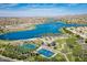 Beautiful aerial view of the community lake, tennis courts, basketball court, playground and palm trees at 18001 W Cassia Way, Goodyear, AZ 85338