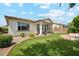 Manicured backyard featuring artificial turf, mature trees and a covered patio at 18001 W Cassia Way, Goodyear, AZ 85338