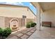 Covered patio showcases a rock water fountain, landscaping, and a tiled walkway, providing a serene retreat at 18001 W Cassia Way, Goodyear, AZ 85338