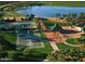 A scenic view of the park showcasing a playground, basketball court, tennis court, and lake at 18001 W Cassia Way, Goodyear, AZ 85338