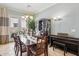 Formal dining room featuring wood table, elegant chandelier, and a view to the outdoor patio area at 18001 W Cassia Way, Goodyear, AZ 85338