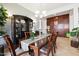 Elegant dining room with wood table, curio cabinet, decorative lighting and attractive paneled accent wall at 18001 W Cassia Way, Goodyear, AZ 85338
