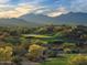 Scenic golf course view with desert landscape, mountain backdrop, and lush green fairway, showcasing a beautiful day on the course at 18001 W Cassia Way, Goodyear, AZ 85338