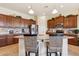 Well-lit kitchen featuring wood cabinets, stainless steel appliances, and a center island with bar seating at 18001 W Cassia Way, Goodyear, AZ 85338