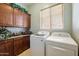 Well-organized laundry room with ample cabinet space, granite countertops, and modern washer and dryer at 18001 W Cassia Way, Goodyear, AZ 85338