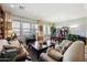 Open-plan living and dining room with sofas, large windows, and a dining set with a china cabinet at 18001 W Cassia Way, Goodyear, AZ 85338