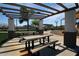 Outdoor picnic area with several tables, trellised shade cover, and landscaping at 18001 W Cassia Way, Goodyear, AZ 85338