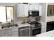 Well-lit kitchen features stainless steel appliances, white cabinets, and modern countertops at 1833 E Bluefield Ave, Phoenix, AZ 85022