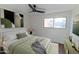 Bedroom with fan, picture window, and relaxing earth-tone colored decor at 5103 S Birch St, Tempe, AZ 85282