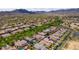 Expansive aerial view captures a lush residential neighborhood surrounded by mature trees, showcasing beautiful homes with mountain scenery at 2305 N Heritage St, Buckeye, AZ 85396
