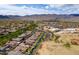 This aerial captures a vibrant residential neighborhood near a large park, set against a backdrop of distant mountain views at 2305 N Heritage St, Buckeye, AZ 85396
