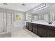 Elegant bathroom featuring a glass shower, soaking tub, dark cabinets, and ample counter space at 2305 N Heritage St, Buckeye, AZ 85396