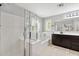 Bright bathroom with a large glass shower, soaking tub, and dark cabinets, offering a spa-like experience at 2305 N Heritage St, Buckeye, AZ 85396