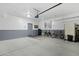 Spacious two-tone garage featuring a dart board, bicycle and a large concrete floor at 2305 N Heritage St, Buckeye, AZ 85396
