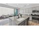 Stylish kitchen with granite counters, a stainless steel stove, an island with a sink, and gray cabinets at 2305 N Heritage St, Buckeye, AZ 85396