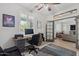 Bright home office featuring a wooden desk, ceiling fan, and open entry into the living room at 2305 N Heritage St, Buckeye, AZ 85396