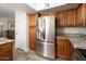 Kitchen featuring stainless steel refrigerator, granite countertops, and wooden cabinets at 4303 E Cactus Rd # 407, Phoenix, AZ 85032