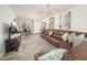 Spacious living room featuring a brown leather sofa, light wood-look floors, and a ceiling fan at 4303 E Cactus Rd # 407, Phoenix, AZ 85032