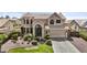 Charming two-story home with manicured landscaping, a tile roof and decorative iron front door at 7157 W Windrose Dr, Peoria, AZ 85381