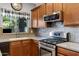 Kitchen with stainless steel appliances, wooden cabinets and a bright window view at 88 W Reeves Ave, San Tan Valley, AZ 85140