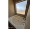 Modern soaking tub features privacy window and chrome fixtures at 23236 W Yavapai St, Buckeye, AZ 85326