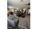 Open-concept living area with modern furnishings, neutral paint palette, with a view of the kitchen and stairs at 23236 W Yavapai St, Buckeye, AZ 85326
