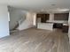 A light-filled room with wood floors, a kitchen with an island, and a white staircase at 2455 W Rowel Rd, Phoenix, AZ 85085