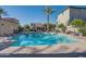 Community pool with a covered seating area, tall palm trees, and meticulously maintained landscaping at 4287 E Tyson St, Gilbert, AZ 85295