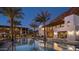 Lush pool area surrounded by palm trees, lounge chairs, and modern architectural buildings at 4849 N Camelback Ridge Rd # A309, Scottsdale, AZ 85251
