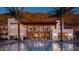 Stunning pool area at dusk, featuring palm trees, lounge chairs, and a well-appointed building at 4849 N Camelback Ridge Rd # A309, Scottsdale, AZ 85251