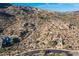 Aerial view of a community with homes blended into the desert landscape, featuring native vegetation and a winding road at 11130 E Rolling Rock Dr, Scottsdale, AZ 85262